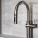 a metal faucet on a tile wall