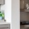 a white kitchen with shelves and bottles